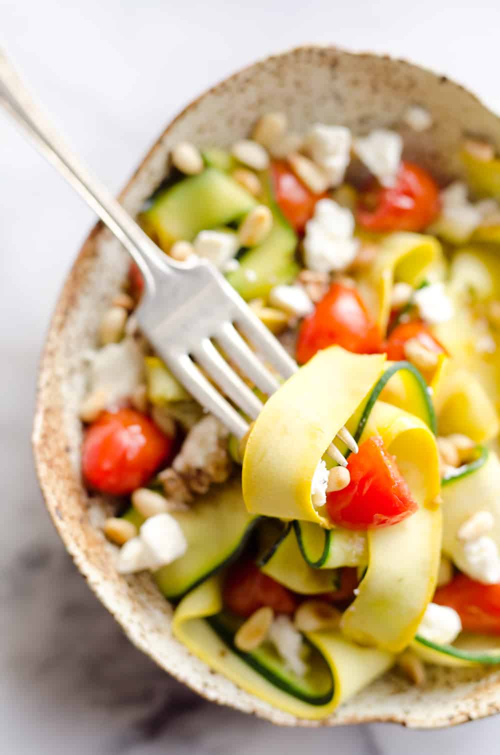 Ribboned Squash & Zucchini Salad is a fresh and healthy vegetarian salad with light veggies, toasted pine nuts, creamy goat cheese and balsamic glaze. Pair it with some grilled shrimp or chicken for an amazing and flavorful dinner you won't forget!