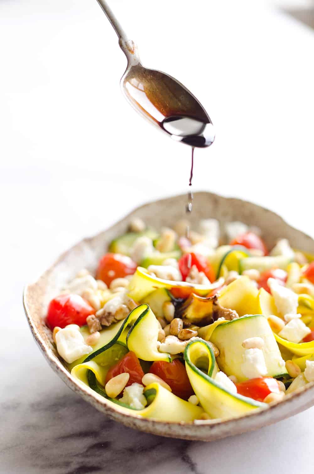 Ribboned Squash & Zucchini Salad is a fresh and healthy vegetarian salad with light veggies, toasted pine nuts, creamy goat cheese and balsamic glaze. Pair it with some grilled shrimp or chicken for an amazing and flavorful dinner you won't forget!