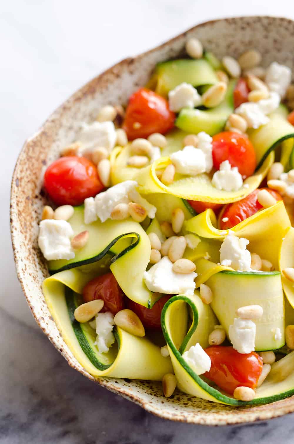 Ribboned Squash & Zucchini Salad is a fresh and healthy vegetarian salad with light veggies, toasted pine nuts, creamy goat cheese and balsamic glaze. Pair it with some grilled shrimp or chicken for an amazing and flavorful dinner you won't forget!