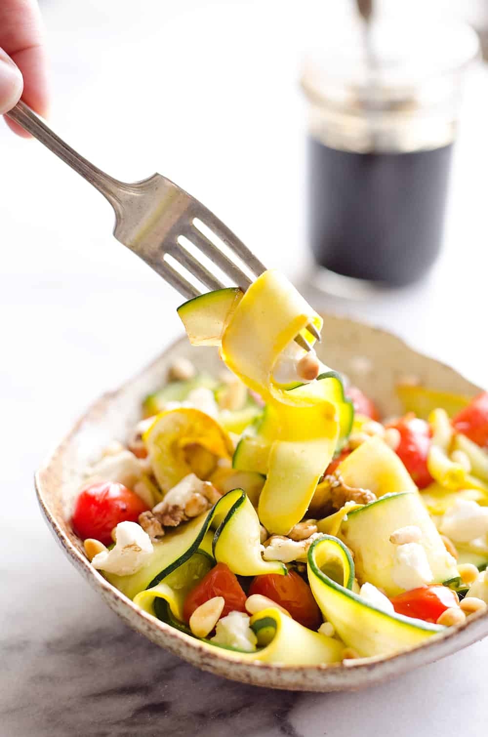 Ribboned Squash & Zucchini Salad is a fresh and healthy vegetarian salad with light veggies, toasted pine nuts, creamy goat cheese and balsamic glaze. Pair it with some grilled shrimp or chicken for an amazing and flavorful dinner you won't forget!