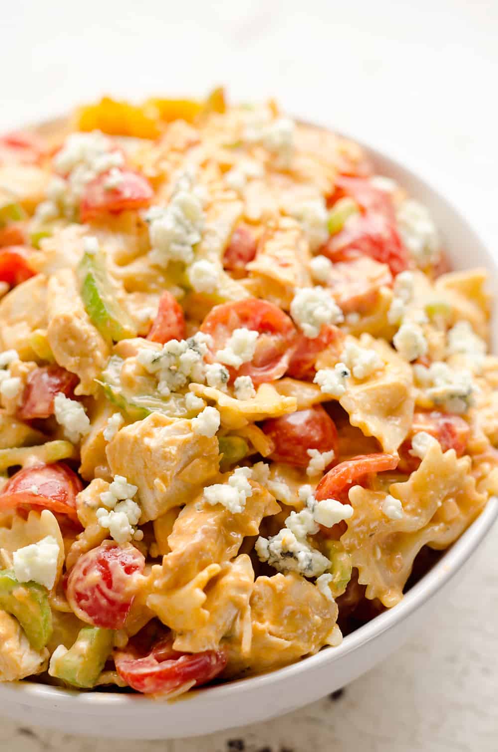 Buffalo Chicken Pasta Salad is a quick and easy recipe perfect for a game day party or a summer picnic. Tender pasta is tossed with a creamy buffalo sauce and fresh vegetables all topped off with crumbled bleu cheese for a side dish bursting with flavor and crunch!