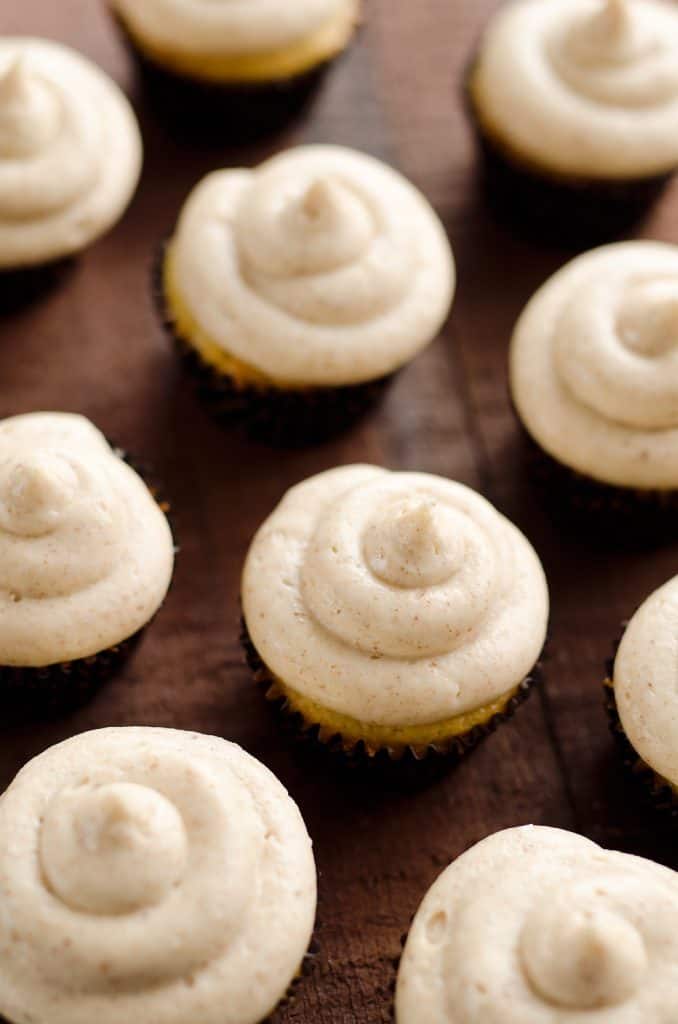 brown buttercream topped cupcakes on wood table