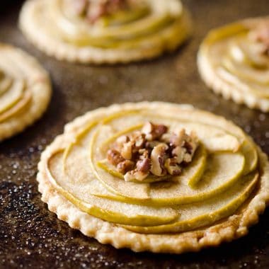 Mini Apple & Browned Butter Tarts are a perfectly light treat with great fall flavors! This dessert includes a flaky pie crust topped with apples and pecans and finished off with decadent browned butter for a bite-sized sweet perfect for holiday parties.