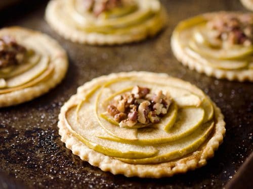 Mini Apple & Browned Butter Tarts are a perfectly light treat with great fall flavors! This dessert includes a flaky pie crust topped with apples and pecans and finished off with decadent browned butter for a bite-sized sweet perfect for holiday parties.