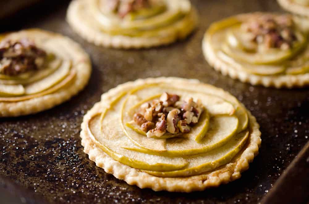 Mini Apple & Browned Butter Tarts are a perfectly light treat with great fall flavors! This dessert includes a flaky pie crust topped with apples and pecans and finished off with decadent browned butter for a bite-sized sweet perfect for holiday parties.