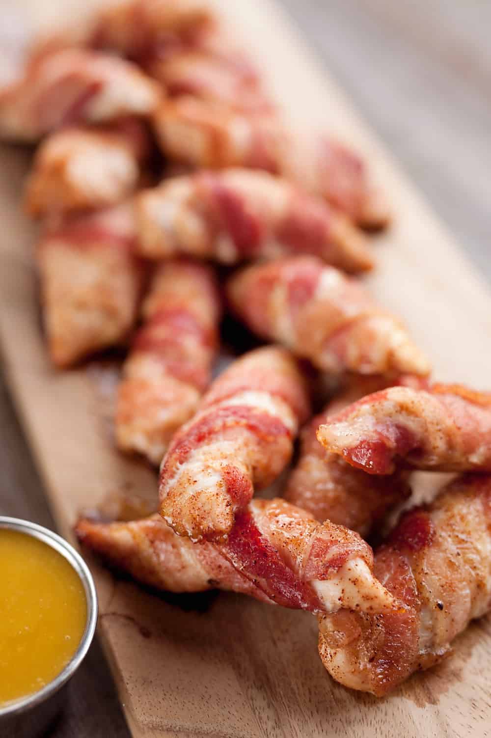 Sweet & Spicy Bacon Wrapped Turkey Tenders are a delicious appetizer paired with a homemade honey mustard for the ultimate game day finger food! They also make a great dinner idea with a side of rice and veggies. 