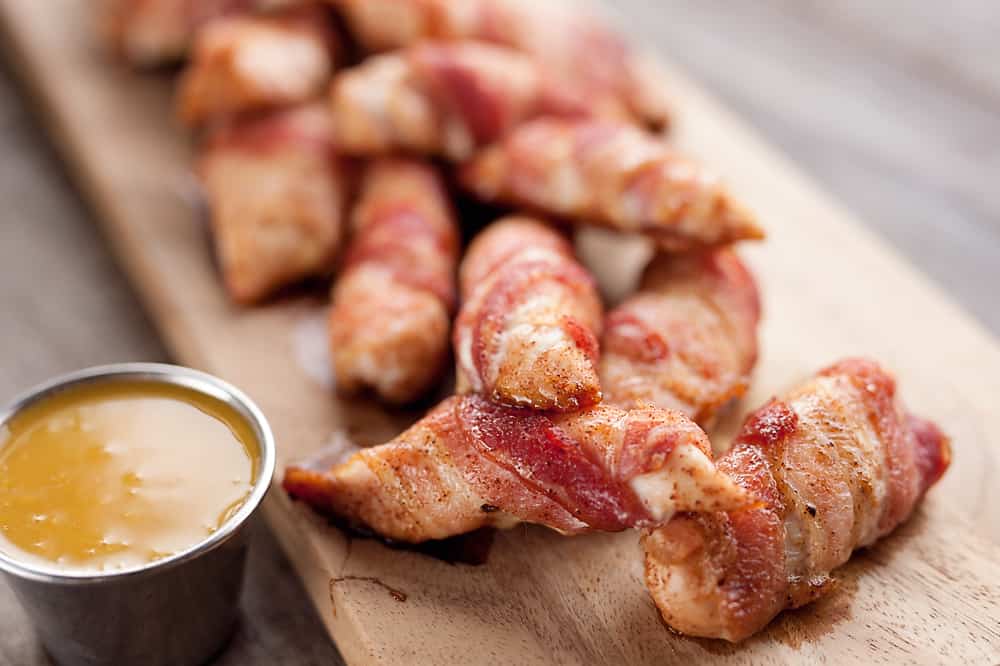 Sweet & Spicy Bacon Wrapped Turkey Tenders are a delicious appetizer paired with a homemade honey mustard for the ultimate game day finger food! They also make a great dinner idea with a side of rice and veggies. 