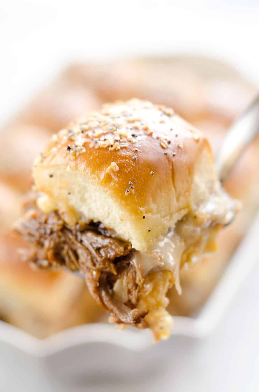 Cheesy BBQ Pork Baked Sliders are an easy family friendly meal with BBQ Pulled Pork and creamy Muenster cheese layered on Hawaiian buns with a butter sauce