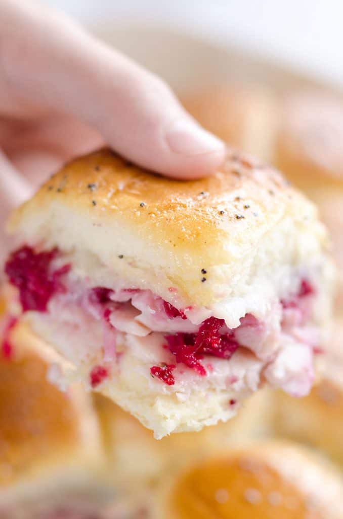 Cheesy Cranberry Turkey Baked Sliders held in hand