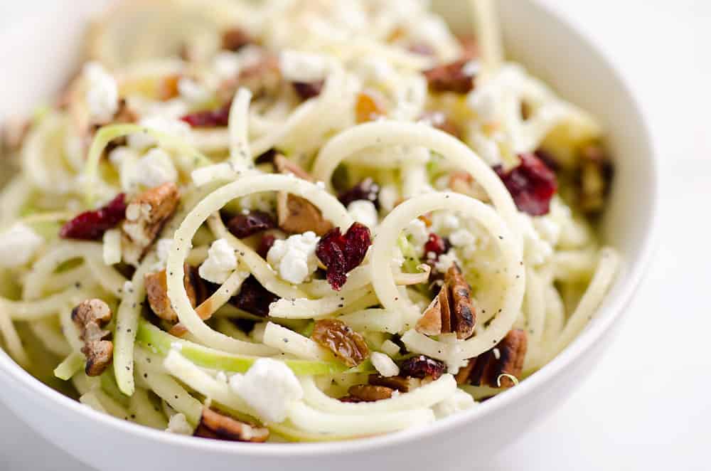 Spiralized Apple Cranberry Salad is an easy and healthy recipe made with crunchy apples, cranberries, pecans and goat cheese all tossed in a light Citrus Poppy Seed Dressing. This salad makes for a a deliciously easy side dish or vegetarian entree you will love!