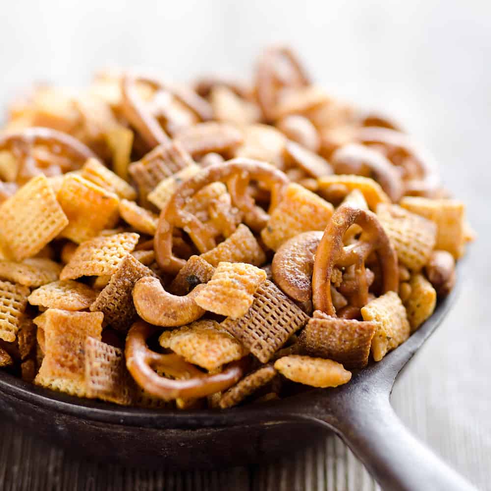 Buffalo Ranch Snack Mix is an easy treat perfect for the big game or holidays. Chex Mix is combined with pretzels and cashews and tossed in a spicy buffalo ranch sauce for a twist on your traditional snack mix. 