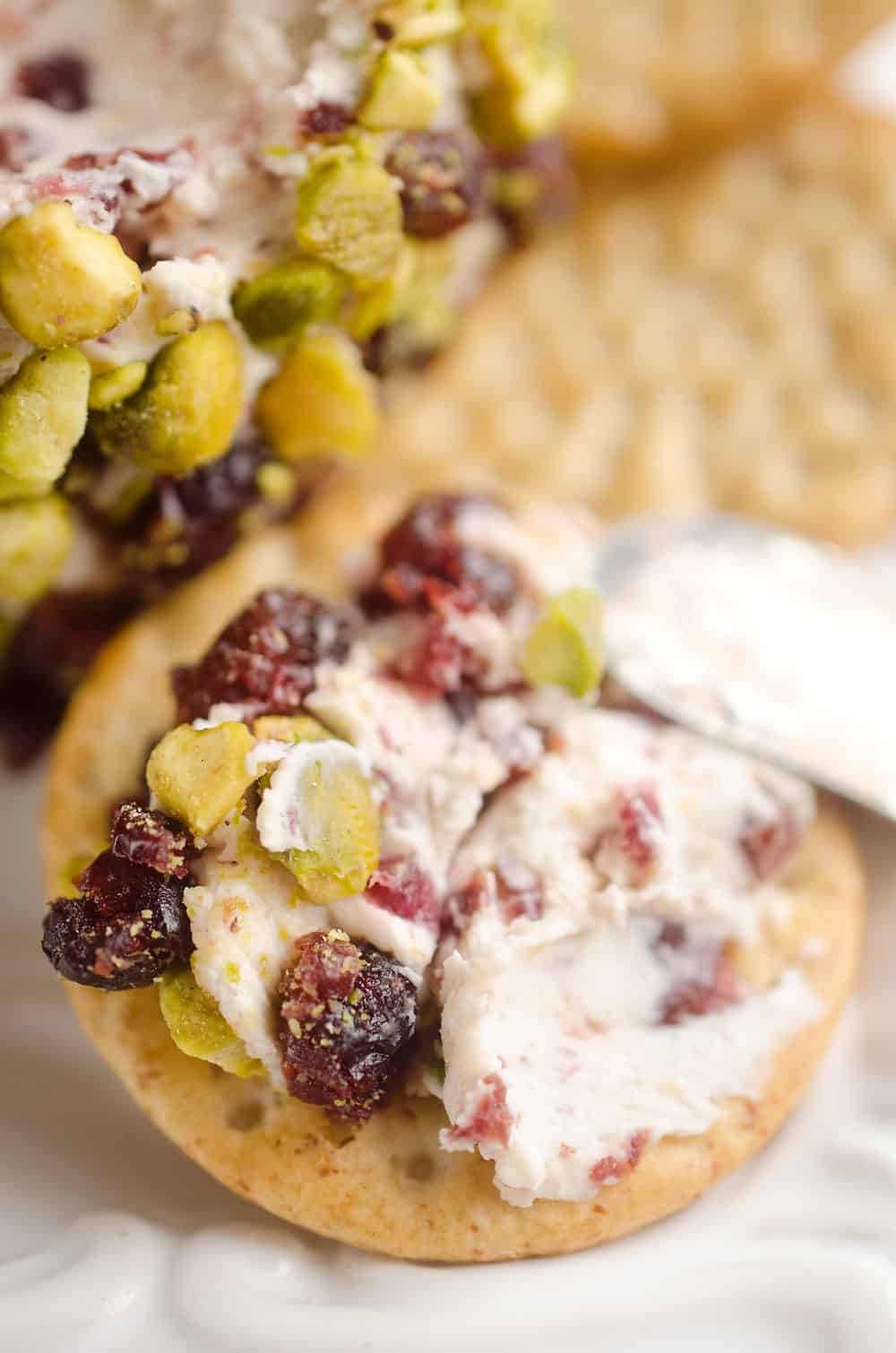 Cranberry Pistachio Cheese Ball is a festive red and green appetizer fantastic for the holidays! A cream cheese and cranberry mixture is rolled in salty pistachios and served with your favorite crackers for the perfect party food. 