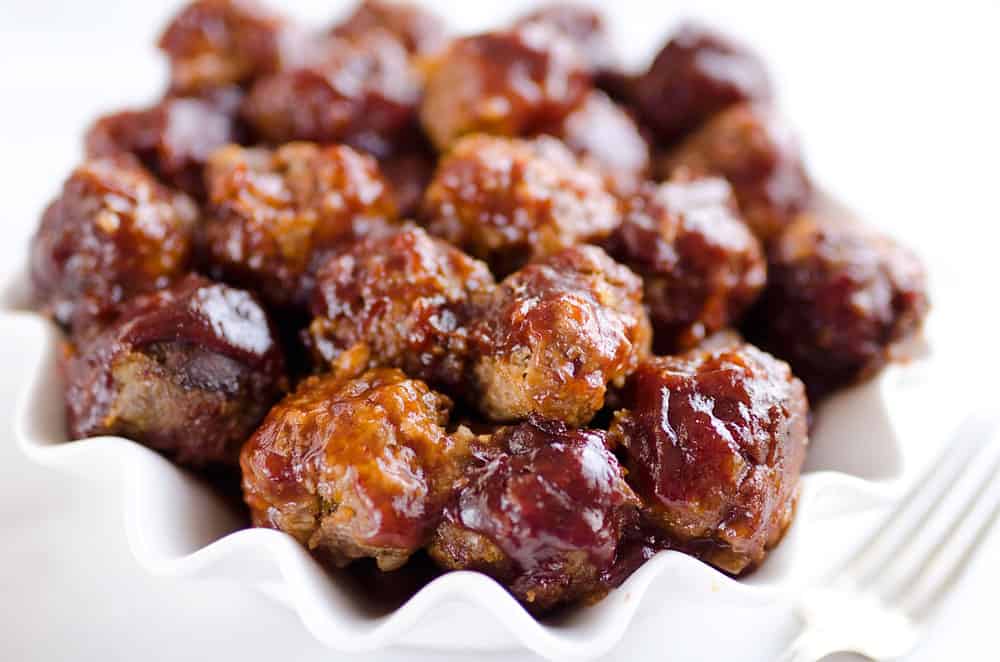 Crock Pot Cheddar BBQ Meatballs make for a flavor packed dinner paired with potatoes or a fantastic appetizer for the big game or holiday bash! Tender beef meatballs loaded with onion and cheese are simmered in your favorite BBQ sauce for a wonderful recipe made in your slow cooker. 