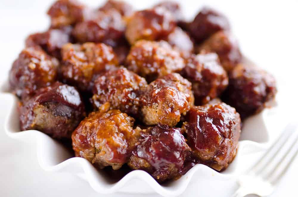 Crock Pot Cheddar BBQ Meatballs make for a flavor packed dinner paired with potatoes or a fantastic appetizer for the big game or holiday bash! Tender beef meatballs loaded with onion and cheese are simmered in your favorite BBQ sauce for a wonderful recipe made in your slow cooker.