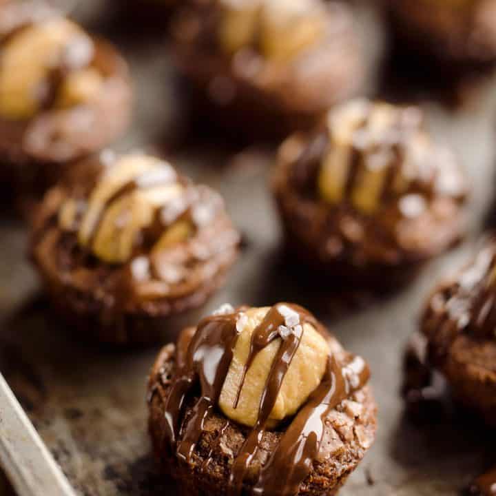 Peanut Butter Buckeye Brownie Cups are the best new dessert recipe you will try! Mini brownies are topped with a Reese's peanut butter filling and drizzled with dark chocolate and sea salt for a spectacular sweet.