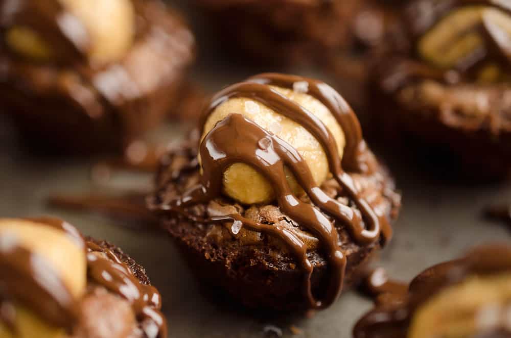 Peanut Butter Buckeye Brownie Cups are the best new dessert recipe you will try! Mini brownies are topped with a Reese's peanut butter filling and drizzled with dark chocolate and sea salt for a spectacular sweet.