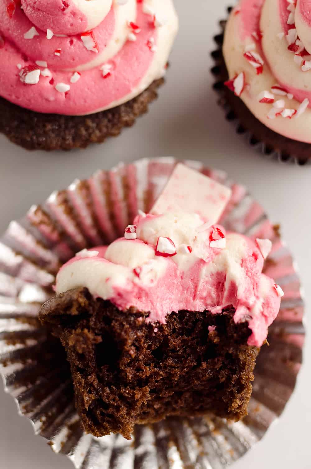 Peppermint Chocolate Candy Cane Cupcakes are a beautifully festive dessert perfect for the holidays! Moist homemade chocolate cupcakes are topped with a candy cane swirl of buttercream and topped with peppermint for a seasonal treat. 