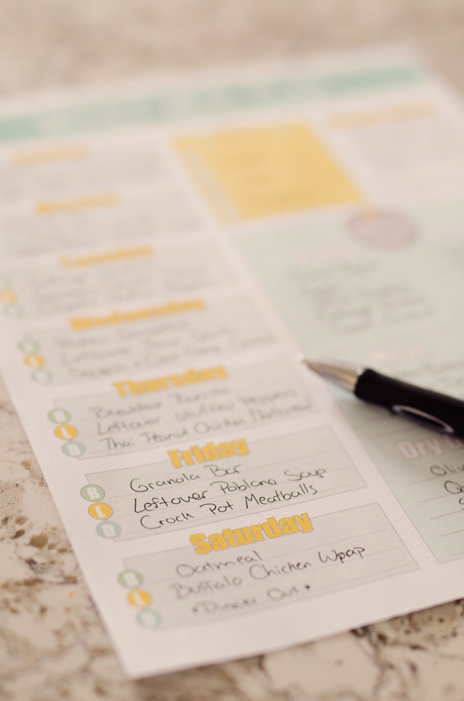 Free Printable Weekly Meal Planner filled out on table with pen