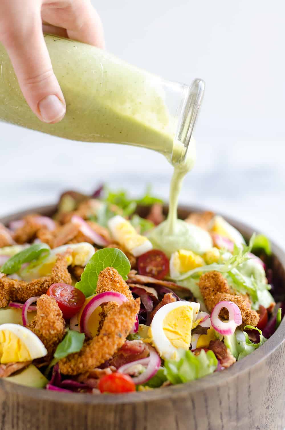 Avocado Lime Green Goddess Sauce is a light and healthy dressing made with creamy Greek yogurt, avocado, garlic and herbs. It is perfect on a salad or as a dipping sauce for chicken and steak!