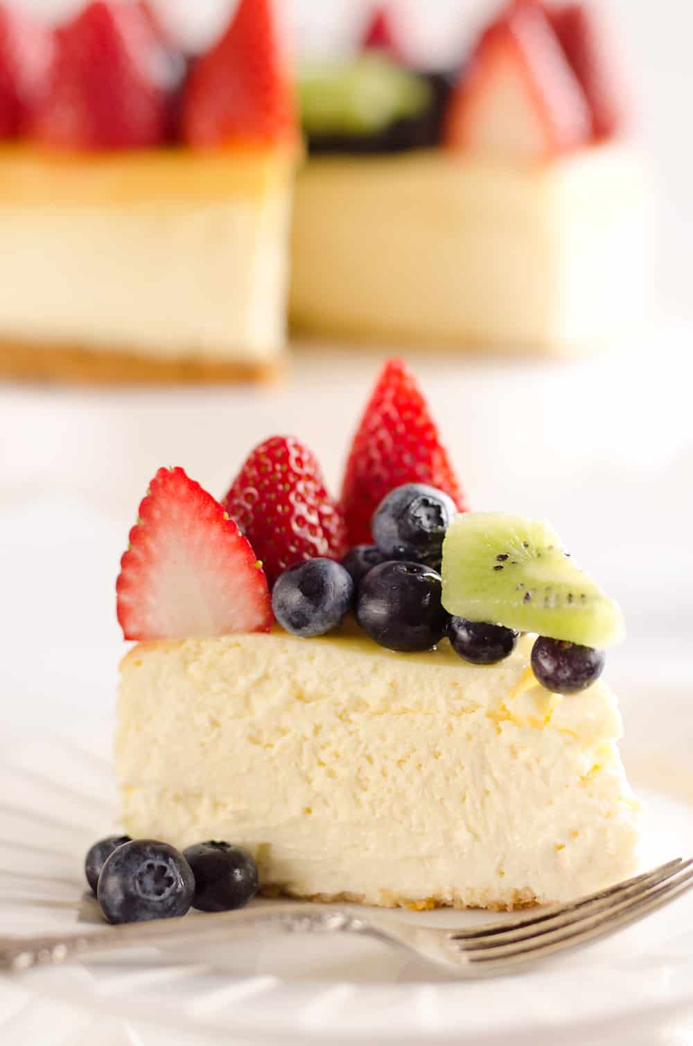 Creamy New York Cheesecake with Fresh Fruit is a rich and decadent dessert recipe that is sure to impress all your dinner guests! 