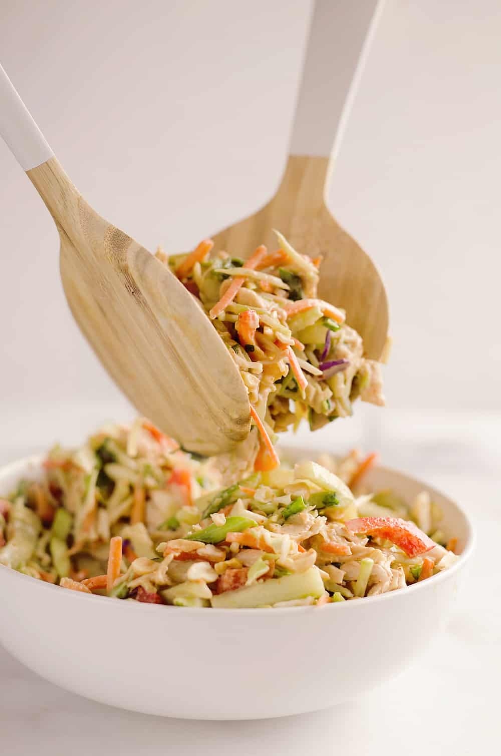 Thai Peanut Chicken Crunch Slaw Salad is an easy & healthy cold salad that is loaded with fresh flavor and crunch! Coleslaw and broccoli slaw are tossed with cucumbers, carrots, bell peppers and chicken and dressed with a homemade Thai Peanut Sauce for a hearty serving of vegetables in a salad you will love.