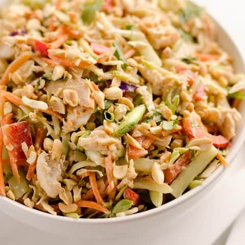 Thai Peanut Chicken Crunch Slaw Salad is an easy & healthy cold salad that is loaded with fresh flavor and crunch! Coleslaw and broccoli slaw are tossed with cucumbers, carrots, bell peppers and chicken and dressed with a homemade Thai Peanut Sauce for a hearty serving of vegetables in a salad you will love.