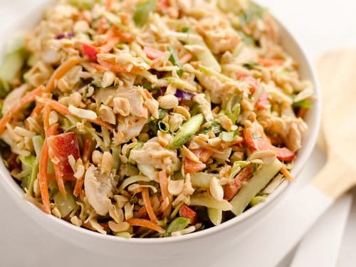 Thai Peanut Chicken Crunch Slaw Salad is an easy & healthy cold salad that is loaded with fresh flavor and crunch! Coleslaw and broccoli slaw are tossed with cucumbers, carrots, bell peppers and chicken and dressed with a homemade Thai Peanut Sauce for a hearty serving of vegetables in a salad you will love.