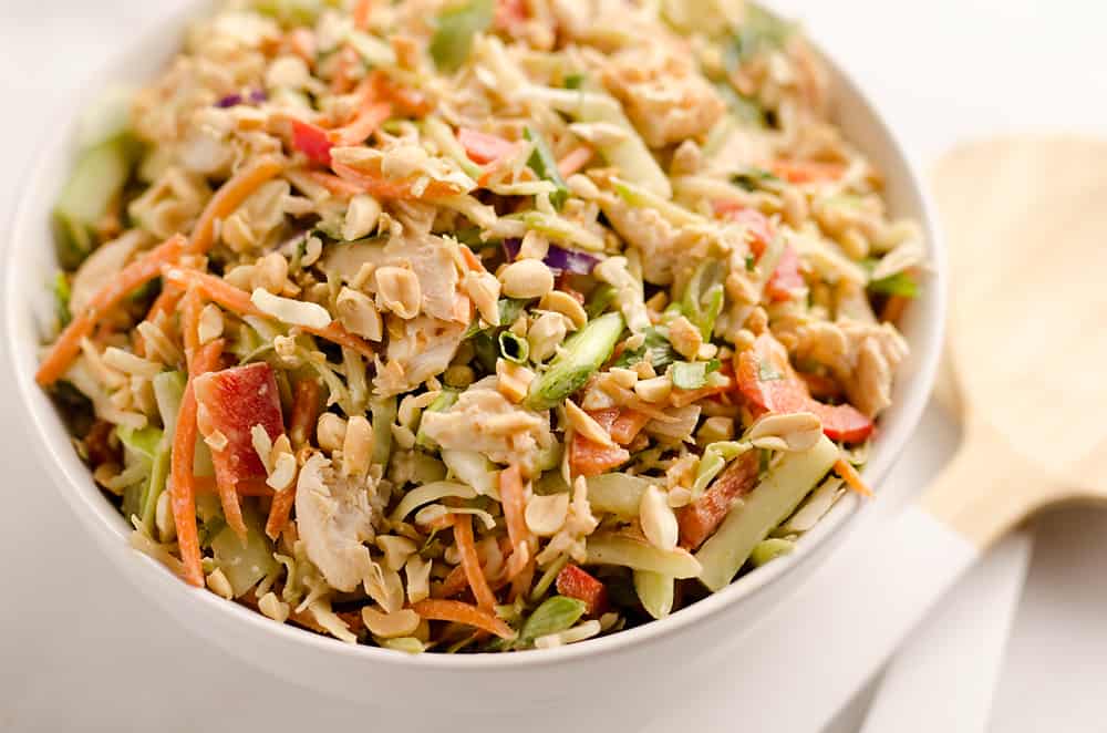 Thai Peanut Chicken Crunch Slaw Salad is an easy & healthy cold salad that is loaded with fresh flavor and crunch! Coleslaw and broccoli slaw are tossed with cucumbers, carrots, bell peppers and chicken and dressed with a homemade Thai Peanut Sauce for a hearty serving of vegetables in a salad you will love.