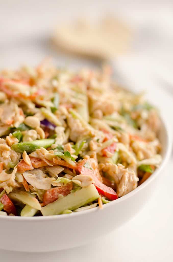 Thai Peanut Chicken Crunch Slaw Salad is an easy & healthy cold salad that is loaded with fresh flavor and crunch! Coleslaw and broccoli slaw are tossed with cucumbers, carrots, bell peppers and chicken and dressed with a homemade Thai Peanut Sauce for a hearty serving of vegetables in a salad you will love.