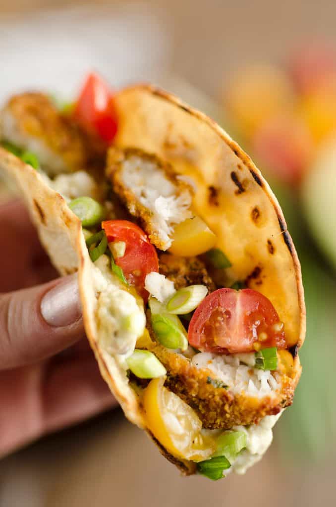 Tortilla Crusted Fish Tacos with Avocado Crema are a healthy and easy weeknight meal you can make in just 20 minutes with your Airfryer! Crispy Tortilla Crusted Tilapia is layered in a grilled corn tortilla with avocado crema and fresh tomatoes for a flavorful dinner recipe the whole family will love.