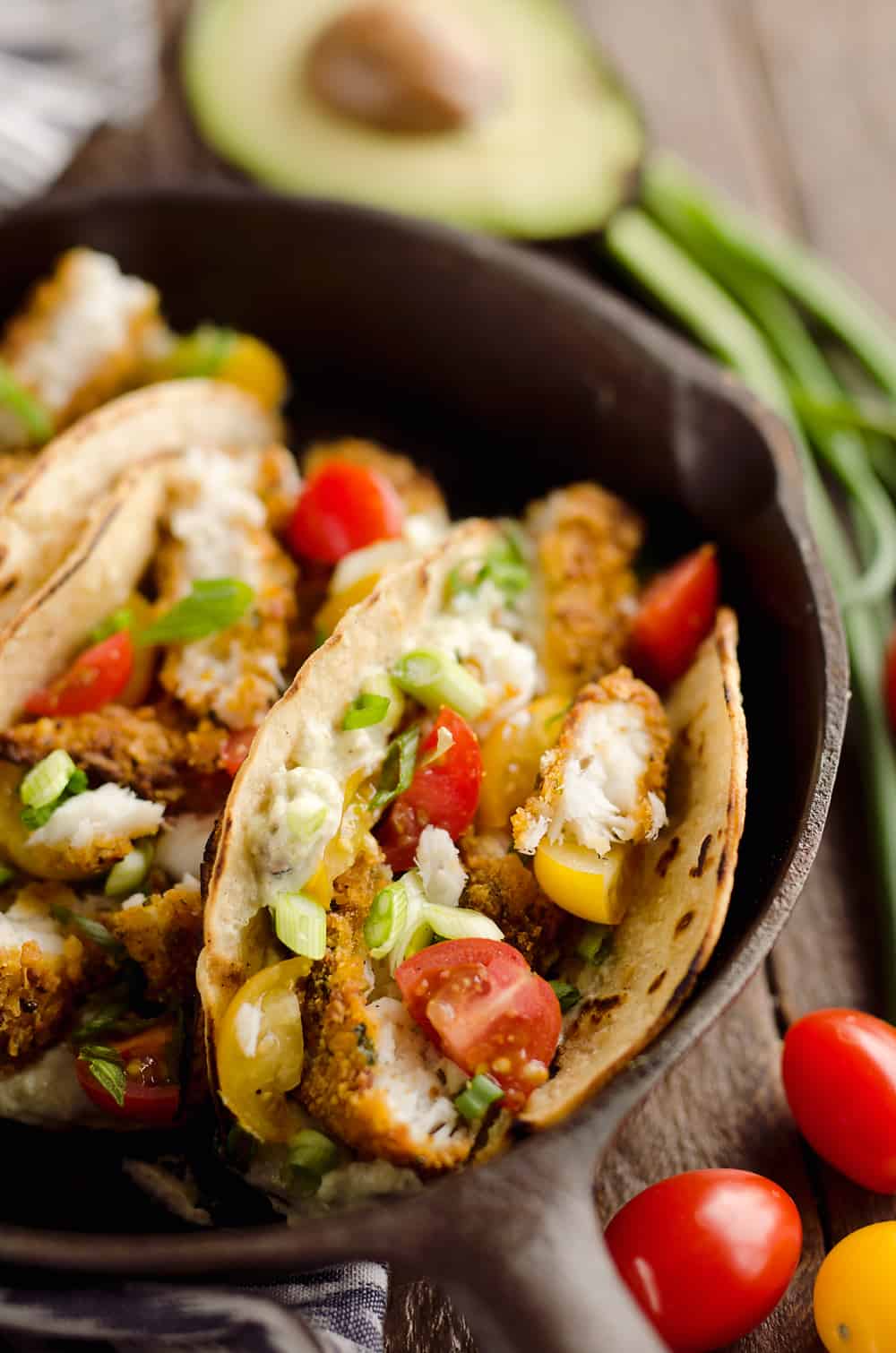 Tortilla Crusted Fish Tacos with Avocado Crema are a healthy and easy weeknight meal you can make in just 20 minutes with your Airfryer! Crispy Tortilla Crusted Tilapia is layered in a grilled corn tortilla with avocado crema and fresh tomatoes for a flavorful dinner recipe the whole family will love. 