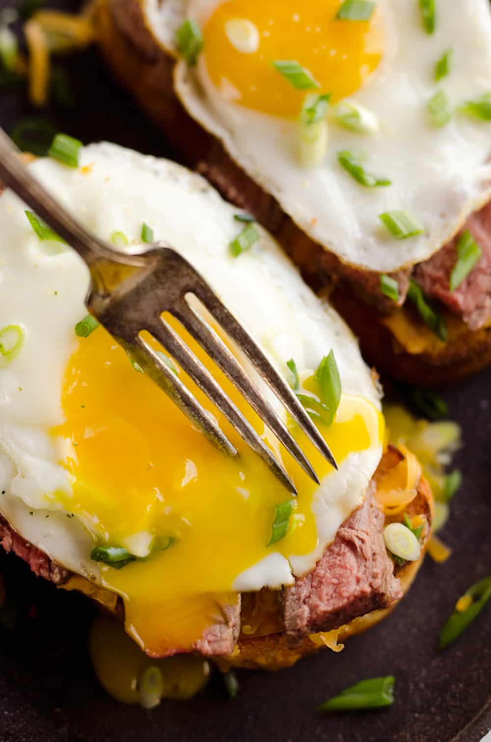 Breakfast Steak & Cheddar Toasts are a rich and decadent recipe filled with all the best parts of brunch. Tender steak is layered on top of a cheesy toast and topped with a sunny side up egg and scallions. 