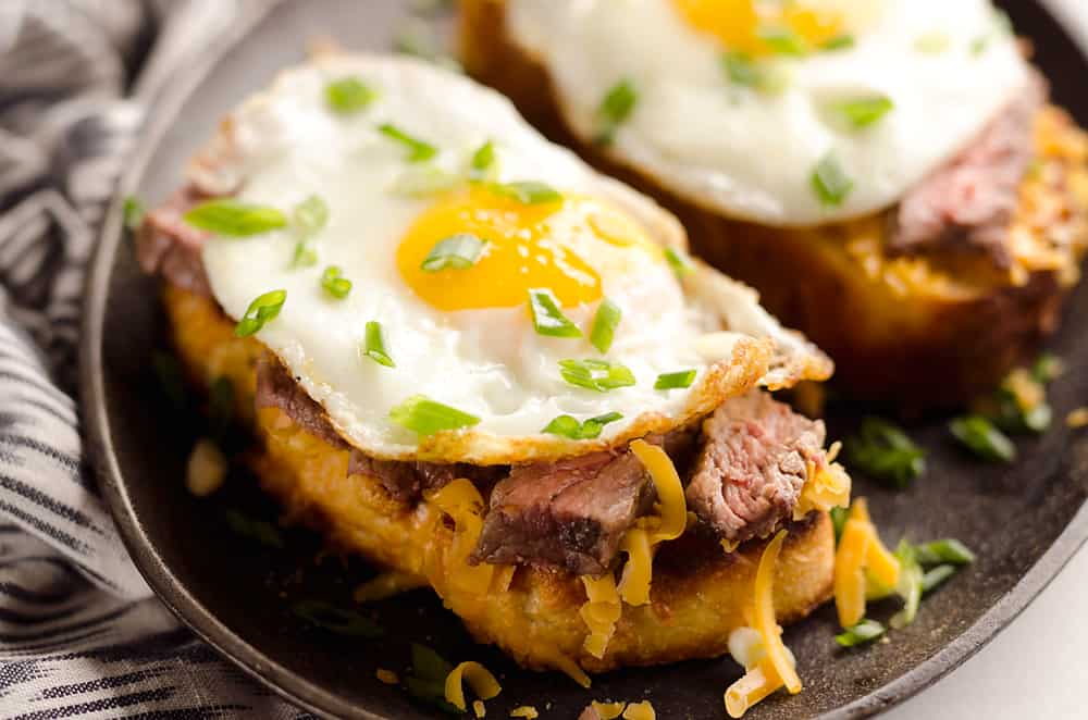 Breakfast Steak & Cheddar Toasts are a rich and decadent recipe filled with all the best parts of brunch. Tender steak is layered on top of a cheesy toast and topped with a sunny side up egg and scallions. 