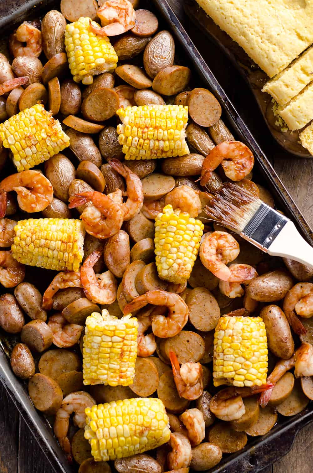 BBQ Shrimp & Sausage Sheet Pan Dinner is an easy and wholesome recipe perfect for a weeknight family dinner. Roasted sweet corn and potatoes are paired with BBQ shrimp and Gold'n Plump Hickory Smoked Sliced Chicken Sausage for a comforting low-fat meal!