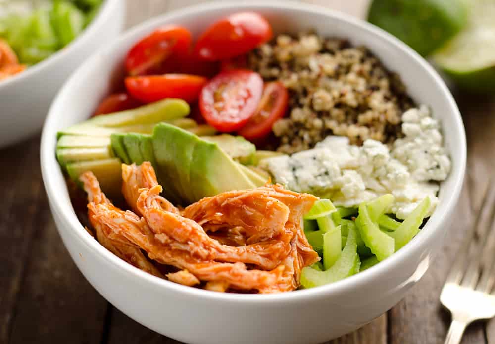 Buffalo Chicken & Quinoa Veggie Bowls are a light and healthy dinner recipe loaded with wholesome vegetables and grains, shredded chicken tossed in spicy buffalo sauce and bleu cheese crumbles for amazing flavor!