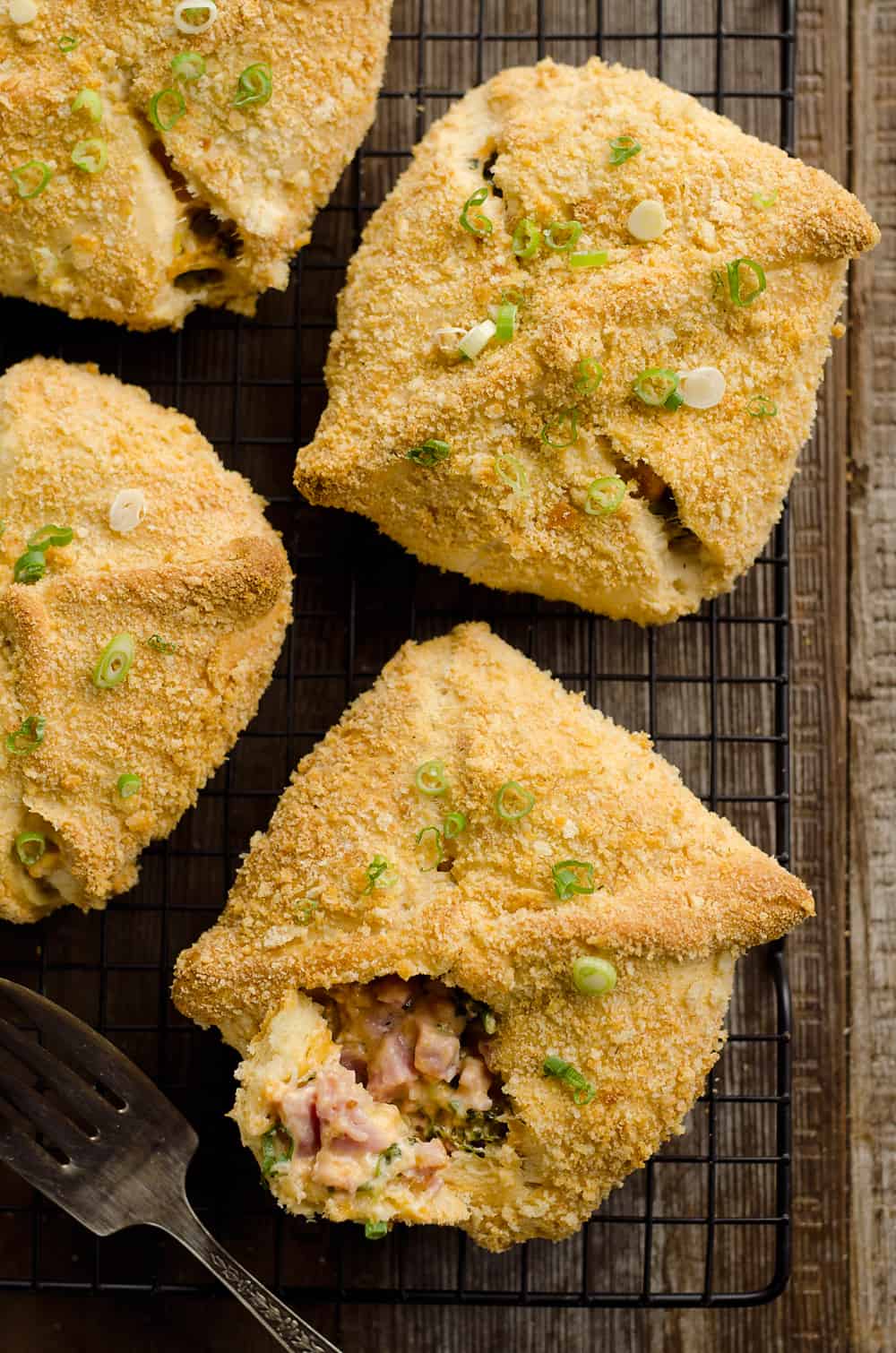 Cheesy Hot Ham & Broccoli Crescent Pockets are a family friendly dinner idea perfect for using up leftover ham! Flaky crescents are filled with a cheddar, broccoli and ham mixture and topped with buttery croutons. 