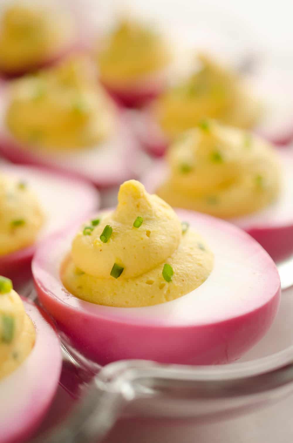 Pink Pickled Deviled Eggs are a beautiful side dish or appetizer perfect for your holiday table. Hard boiled eggs are lightly pickled in beet juice and vinegar for the unique color that is sure to impress your guests!