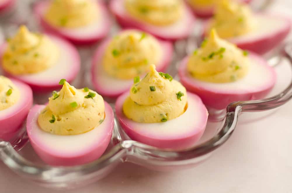 Pink Pickled Deviled Eggs are a beautiful side dish or appetizer perfect for your holiday table. Hard boiled eggs are lightly pickled in beet juice and vinegar for the unique color that is sure to impress your guests!