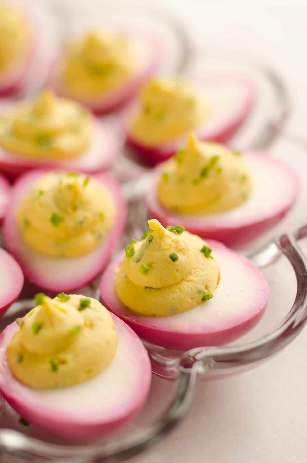 Pink Pickled Deviled Eggs are a beautiful side dish or appetizer perfect for your holiday table. Hard boiled eggs are lightly pickled in beet juice and vinegar for the unique color that is sure to impress your guests!