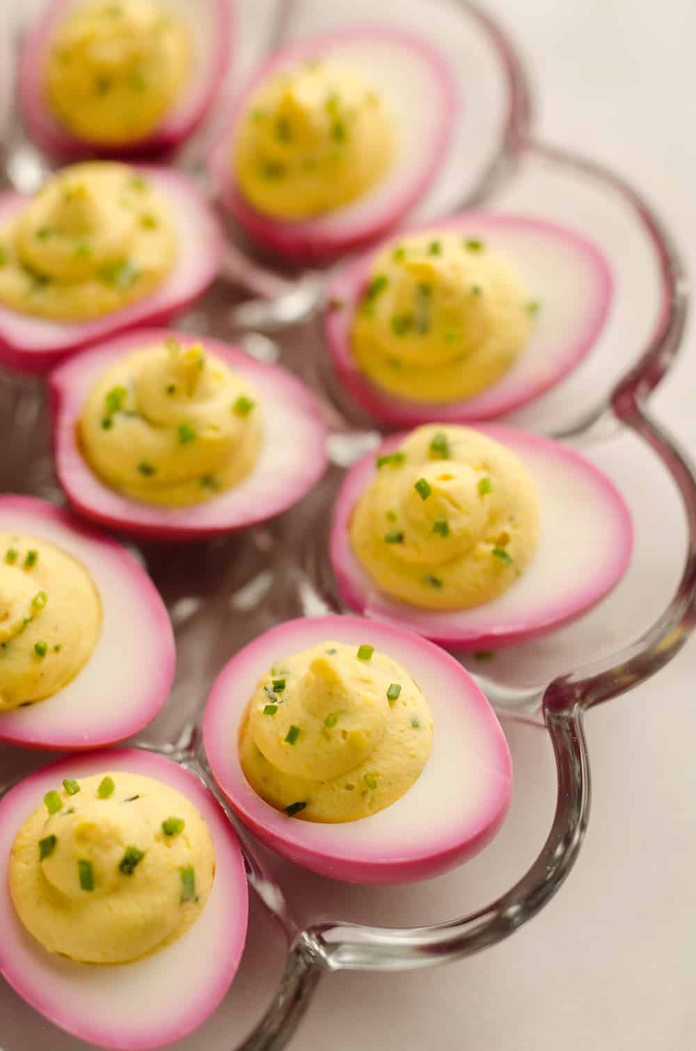 Pink Pickled Deviled Eggs are a beautiful side dish or appetizer perfect for your holiday table. Hard boiled eggs are lightly pickled in beet juice and vinegar for the unique color that is sure to impress your guests!