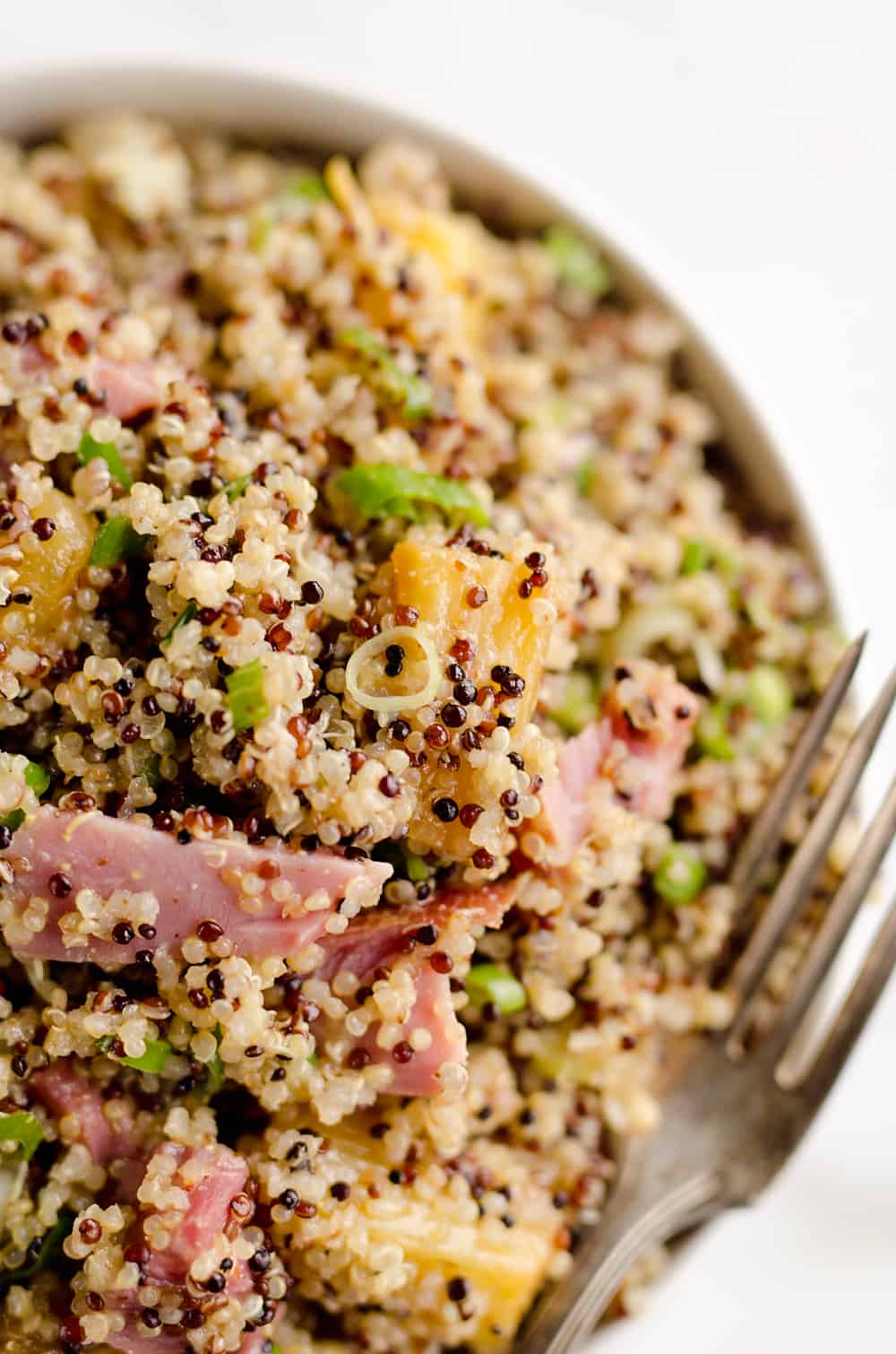 Roasted Pineapple & Ham Quinoa Salad is an easy recipe using up leftover ham with the perfect combination of sweet, salty and smokey flavors. Crunchy quinoa and oven roasted pineapple and ham are tossed with a Light Honey Dijon Vinaigrette for an easy 5 ingredient salad. 