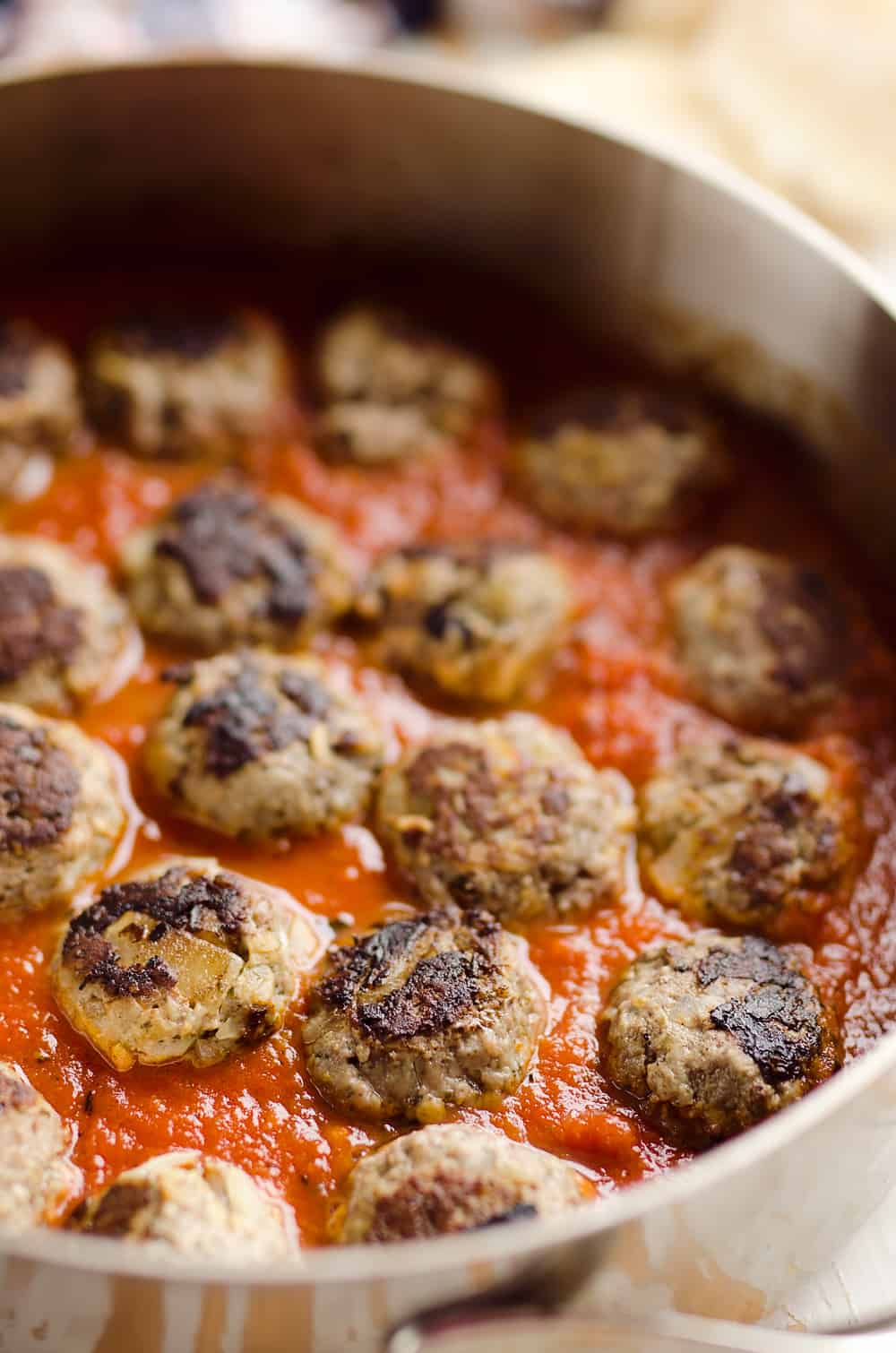 Provolone Stuffed Pesto Meatball Skillet is a hearty dinner made with classic Italian flavors. Provolone cheese is stuffed inside lean hamburger and simmered in marinara for a healthy dinner idea the whole family will love.