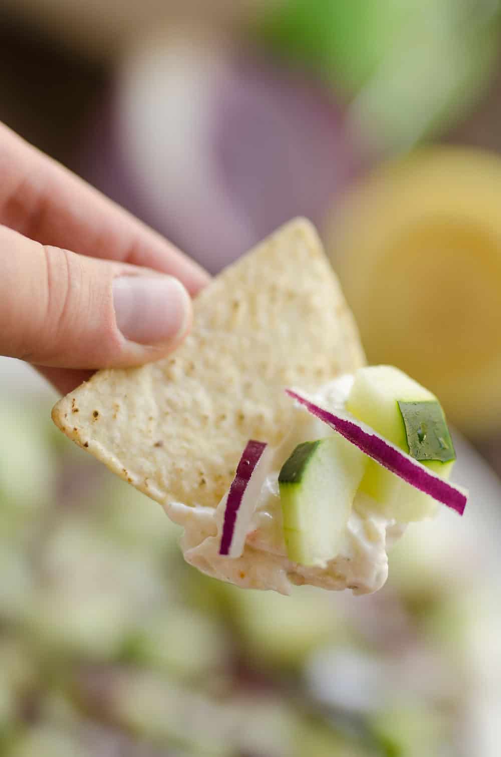 Creamy Cucumber Layered Dip is an easy 10 minute recipe perfect for a flavorful summer snack. A lightened up layer of creamy goodness is topped with fresh cucumbers and onions and served with Mission Organics Tortilla Chips for a wholesome dish you will love!