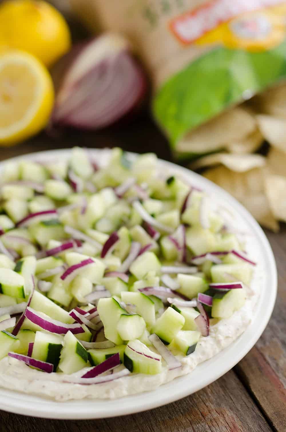 Creamy Cucumber Layered Dip is an easy 10 minute recipe perfect for a flavorful summer snack. A lightened up layer of creamy goodness is topped with fresh cucumbers and onions and served with Mission Organics Tortilla Chips for a wholesome dish you will love!
