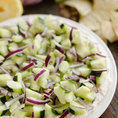 Creamy Cucumber Layered Dip is an easy 10 minute recipe perfect for a flavorful summer snack. A lightened up layer of creamy goodness is topped with fresh cucumbers and onions and served with Mission Organics Tortilla Chips for a wholesome dish you will love!