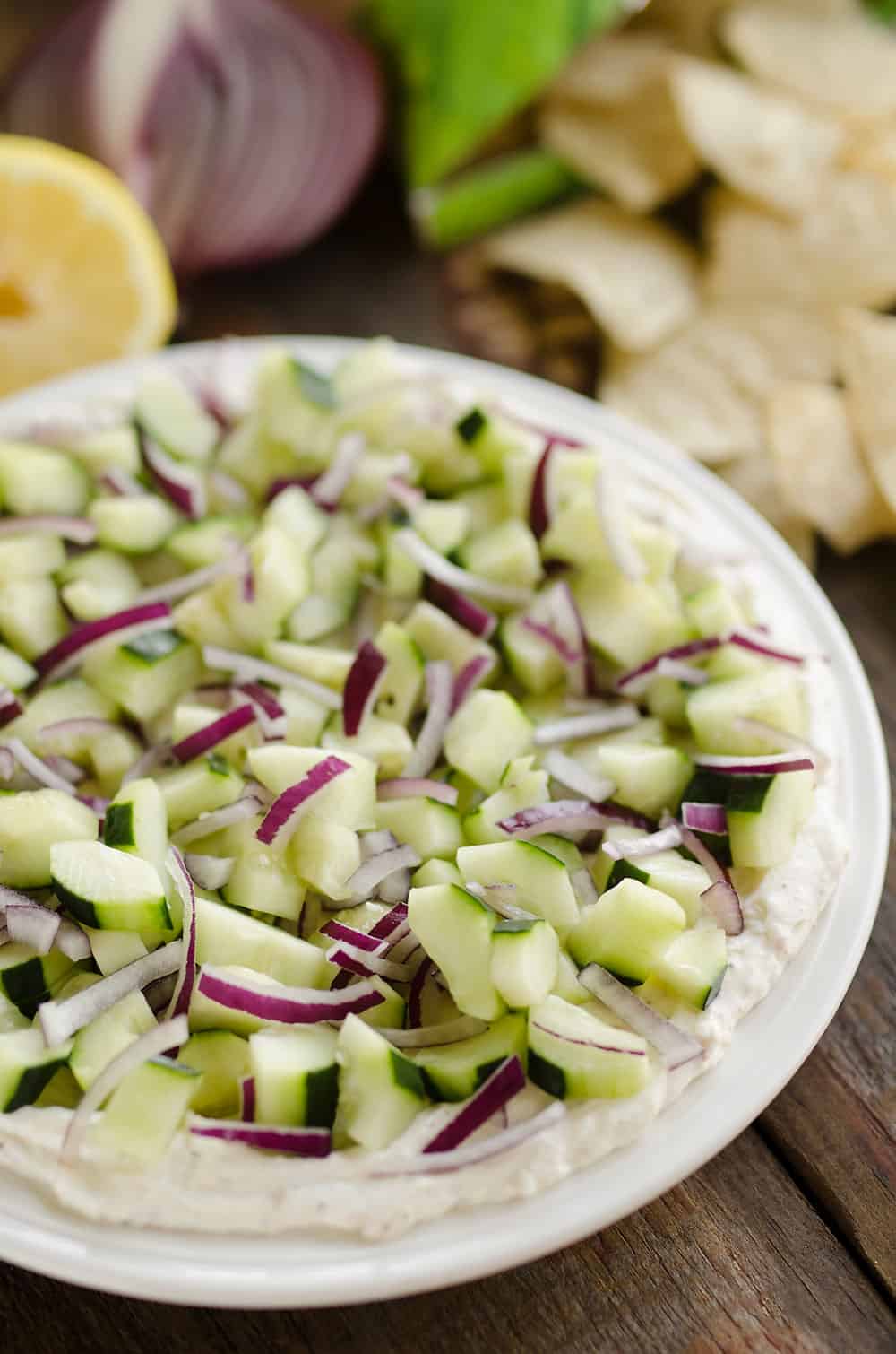 Creamy Cucumber Layered Dip is an easy 10 minute recipe perfect for a flavorful summer snack. A lightened up layer of creamy goodness is topped with fresh cucumbers and onions and served with Mission Organics Tortilla Chips for a wholesome dish you will love!