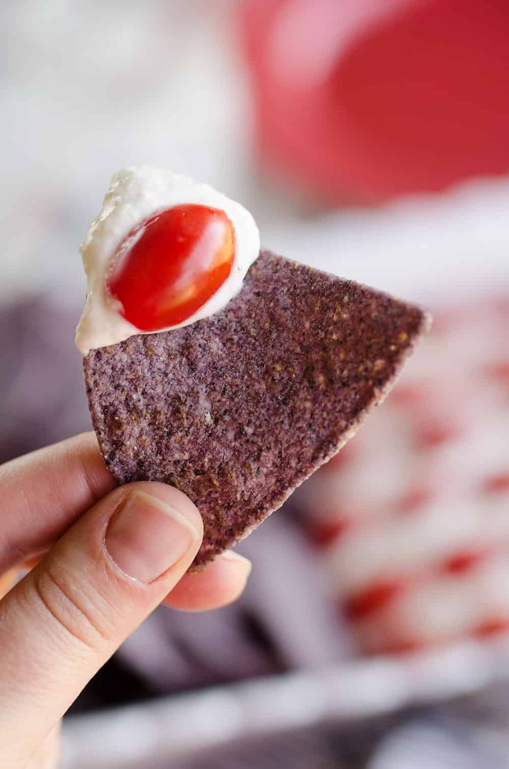 Patriotic Flag Parmesan Garlic Chip Dip is a festive appetizer recipe perfect for a holiday party with red, white and blue colors! A creamy Parmesan garlic dip is topped with cherry tomatoes and served with blue corn tortilla chips for a delicious dish sure to be a crowd pleaser. 