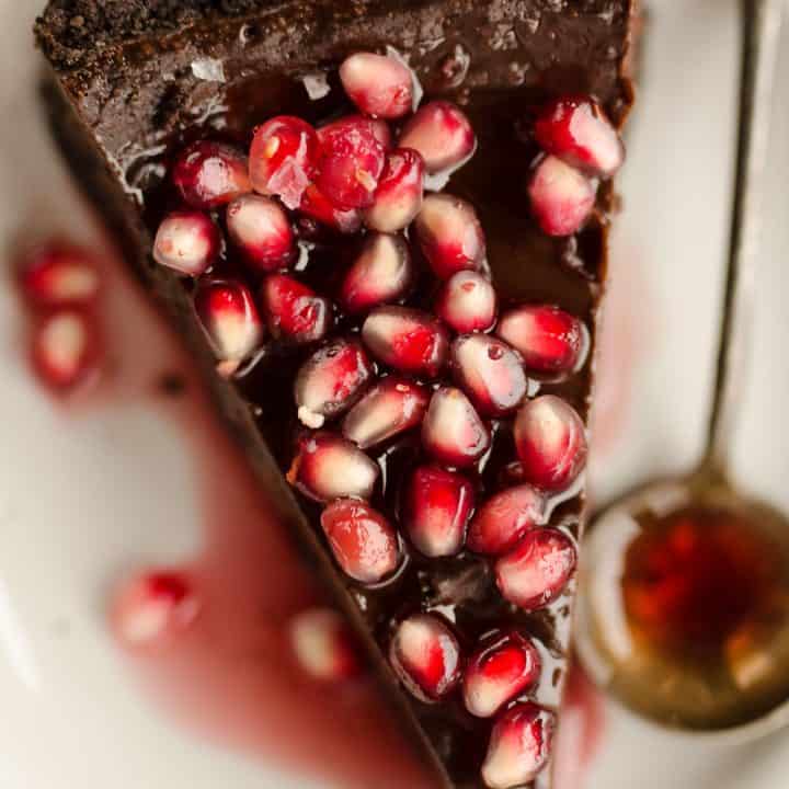 Salted Dark Chocolate Pomegranate Tart slice on plate