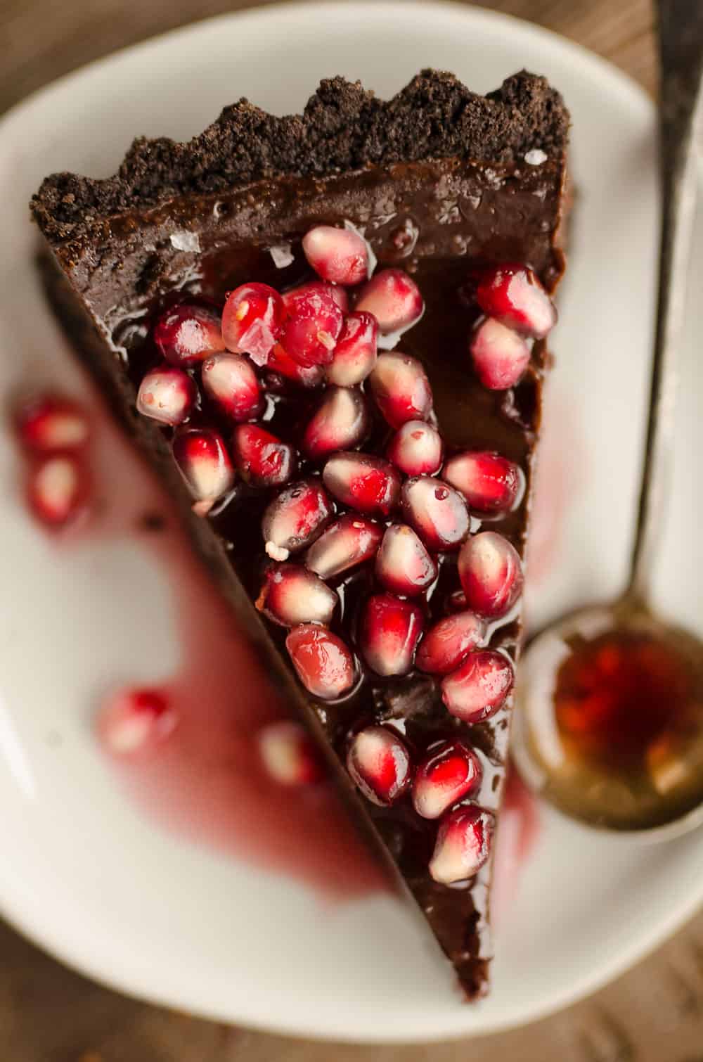 Salted Dark Chocolate Pomegranate Tart slice on plate