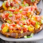 Scrambled Egg and Bacon Sweet Potato Skins on white platter by eggs